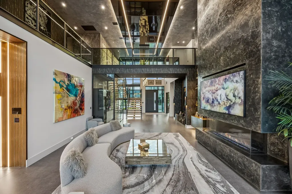 Curved sofa and marble-patterned rug beneath a two-story glass hall
