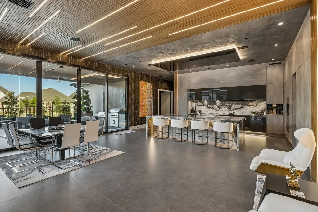 Open kitchen and dining area under a wood-slat ceiling with light strips