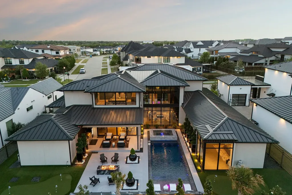 Aerial view of the home's courtyard pool and rear terraces at dusk