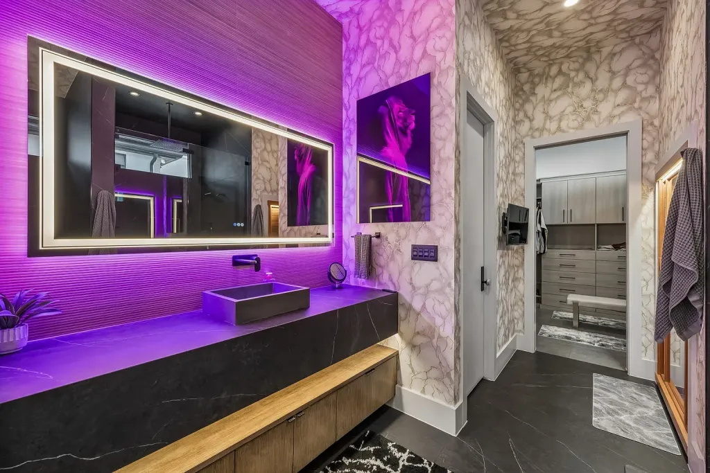 Floating stone vanity with a backlit mirror and accent lighting