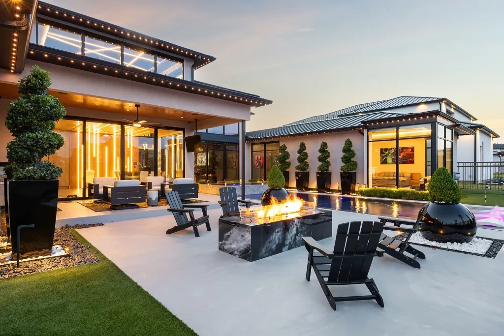 Patio with Adirondack chairs around a fire table at dusk