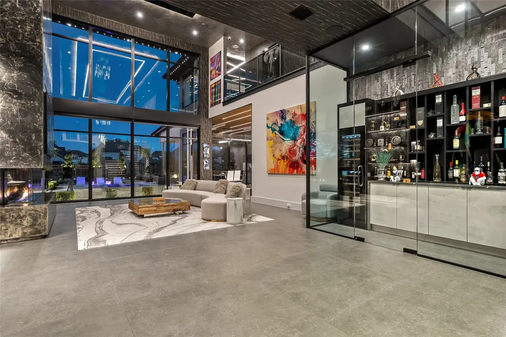 Double-height living room beside a glass-walled wine display