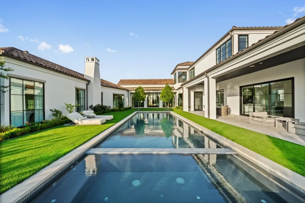 Long lap pool through a courtyard lawn between the wings of the house