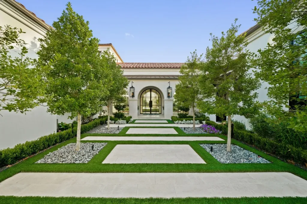 Frisco estate courtyard with a long lawn walkway leading to an arched entry
