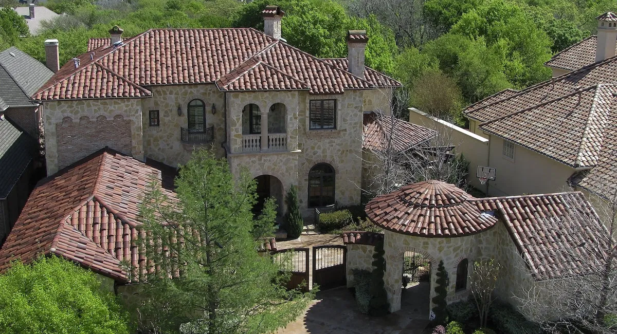 Aerial view of a Tuscan-inspired stone estate with terracotta roofs