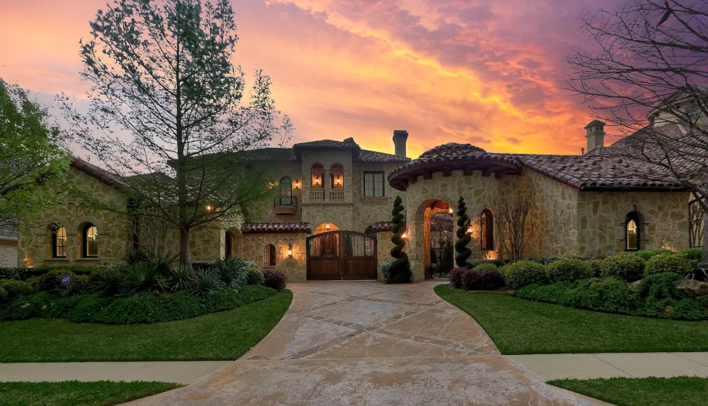 Stone Tuscan-style estate with arched entries under a sunset sky